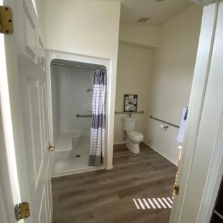 A modern, accessible bathroom with a spacious shower and handrails.