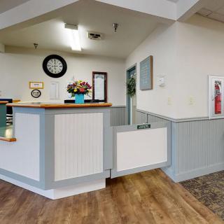 A reception area with a desk, clock, and decorative elements.