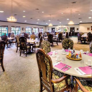 A well-decorated dining area with neatly arranged tables and chairs, set for guests.
