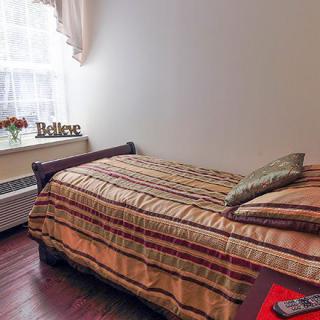 A cozy bedroom with a single bed and decorative elements by the window.