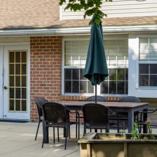 A patio with outdoor furniture set against a brick wall.