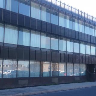 A modern office building with a glass facade in an urban setting.