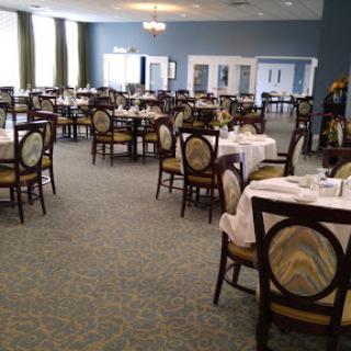 A spacious dining area set for guests, featuring neatly arranged tables and chairs.