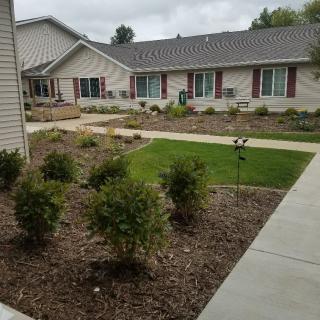 A landscaped garden area with bushes and pathways outside a residential building.