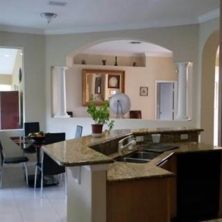 A modern kitchen with an island countertop and adjoining dining area.