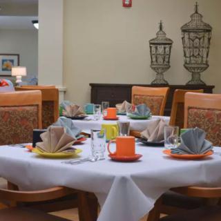A neatly set dining table with colorful dishes and napkins in a cozy restaurant setting.