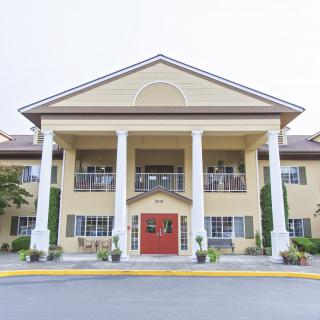 A two-story building with a symmetrical front and prominent columns.