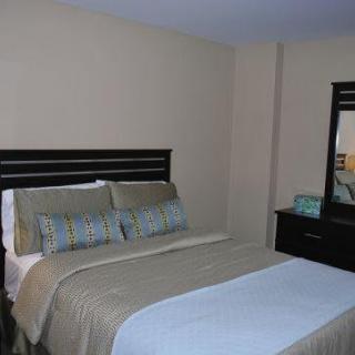 A cozy bedroom with a neatly made bed and matching furniture.