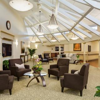 A modern lounge area with comfortable seating and ample natural light from skylights.