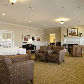 A cozy living room with multiple seating areas and warm lighting.