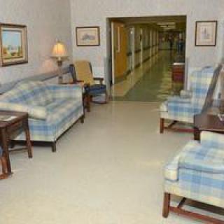 A cozy lounge area with plaid sofas and chairs near a hallway.