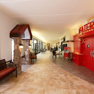 A spacious hallway with seating areas and a theater entrance.