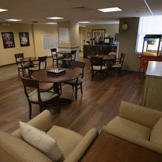 A cozy lounge area with tables, chairs, and soft lighting.