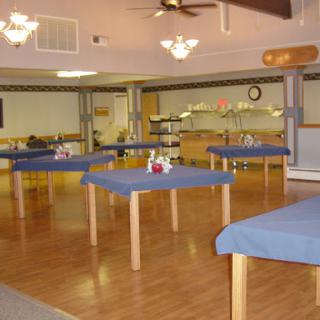 A spacious dining area featuring tables with blue cloths, ready for customers.