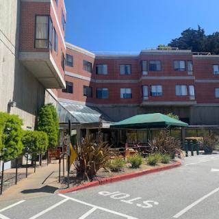 A sunny day at a residential facility featuring outdoor seating and well-maintained landscaping.