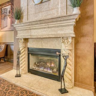 A luxurious traditional fireplace with decorative pillars and a cozy ambiance.