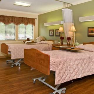 A well-maintained hospital room with two beds and medical equipment.