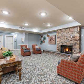 A cozy living room featuring a stone fireplace and comfortable seating arrangements.
