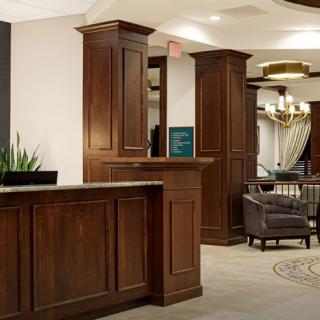 A hotel lobby featuring a wooden reception desk and cozy seating area.
