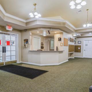 A spacious lobby with a reception desk and modern lighting fixtures.