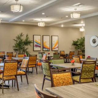 A spacious dining room with colorful chairs and modern decor.