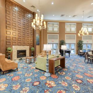 Elegant lobby with chandeliers, a fireplace, and colorful decor.