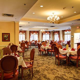An elegant restaurant dining area with neatly arranged tables and classic chandeliers.