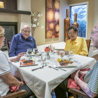 A group of seniors enjoying a meal together at a dining table.