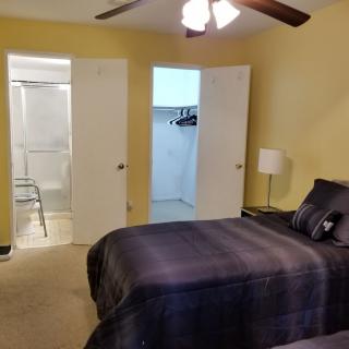 A cozy bedroom with a bed, closet, and an adjoining bathroom.