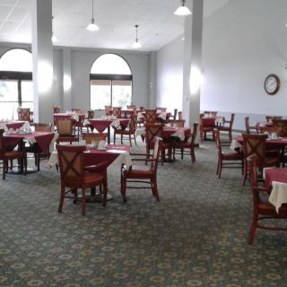 An empty dining room with neatly arranged tables and chairs.