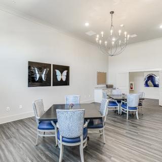 A modern dining area with elegant lighting and butterfly artwork on the walls.