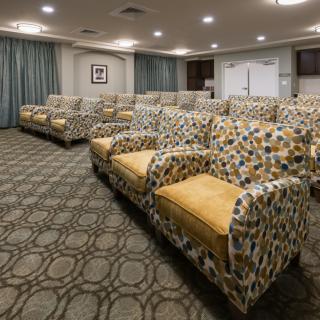 A modern conference room with patterned seating and a carpeted floor.