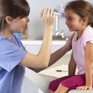 A pediatrician conducting a health checkup on a young girl in a clinic.