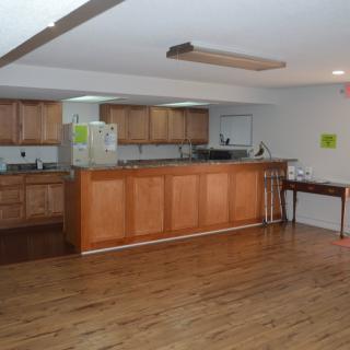 A spacious kitchen with wooden cabinets and a hardwood floor.