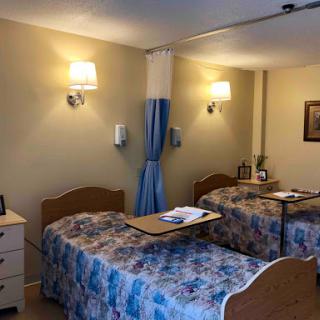 A cozy hospital room with two beds and warm lighting.