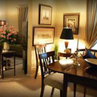 A cozy dining room with warm lighting, featuring elegant furniture and artwork.