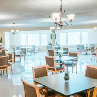 A bright and spacious dining room with tables and chairs arranged neatly under elegant lighting.