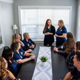 A group of people having a meeting around a conference table in an office.
