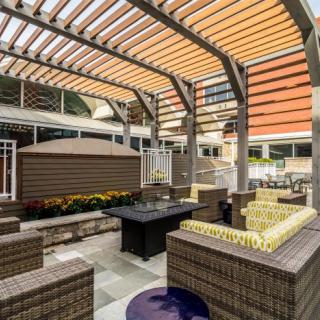 A modern outdoor patio with a stylish pergola and comfortable seating area.