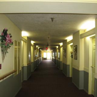 A long, brightly lit hallway with doors on either side.