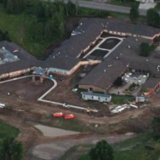 Aerial view of a building under construction surrounded by greenery.