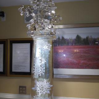 An artistic centerpiece featuring a lit decorative vase with snowflake designs, enhancing the cozy ambiance.