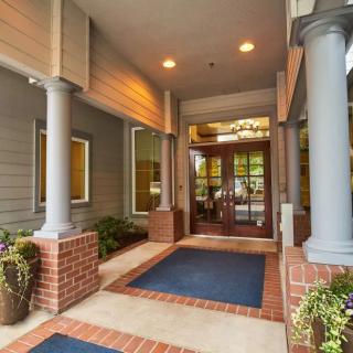 Entrance to a building with columns and decorative plants.