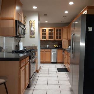 A modern kitchen with wooden cabinets and stainless steel appliances.