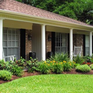 A cozy house with a landscaped garden and a welcoming front porch.