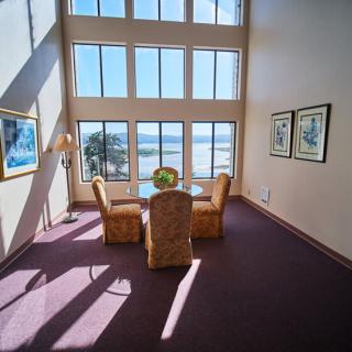 A bright and spacious room with large windows offering a stunning ocean view and a cozy dining area.