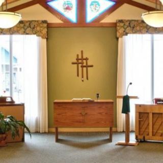 A church interior with an altar and decorative cross.