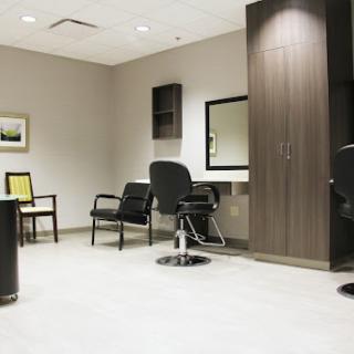 A modern salon interior featuring a waiting area with chairs and a mirror.