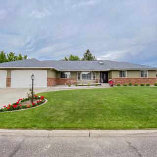 Single-story suburban house with a well-maintained lawn and driveway.