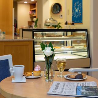 A cozy cafe table with pastries, coffee, and a newspaper.